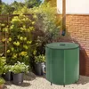 A green rain barrel is shown in a garden setting, connected to a downspout from a building. Náhled obrázku produktu