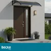 A brown double door with a glass panel, covered by a black awning, on a white wall. There are potted plants on the porch. Náhled obrázku produktu