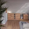 A modern living room with a wooden cabinet against a wall, a large plant in the foreground, and a sofa in the lower right corner. Náhled obrázku produktu