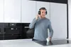 A man wearing headphones in a modern kitchen. Podgląd zdjęcia produktu