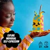 A child is holding a colorful LEGO pencil holder. Podgląd zdjęcia produktu