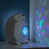 A plush hedgehog toy projecting stars onto a wall, set on a shelf. Voir les images du produit