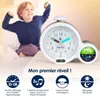 A child is stretching in bed next to an alarm clock. Produktbild-Vorschau