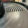 Close-up of a metal grill grate with a black handle. Produktbild-Vorschau