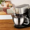 A person is adding flour to a kitchen mixer. Produktbild-Vorschau