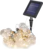A string of solar-powered LED light bulbs with a solar panel on a stake. Produktbild-Vorschau