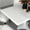A white dining table with a transparent protective film on top, set in a dining room with white chairs. Anteprima dell’immagine prodotto