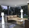 An outdoor patio area with a sofa, coffee table, and two floor lamps. Anteprima dell’immagine prodotto