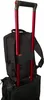 A black backpack is attached to the handle of a rolling suitcase. Produktbild-Vorschau