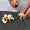 A close-up shot of someone slicing mushrooms on a cutting board. Anteprima dell’immagine prodotto