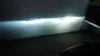 Two bright white light beams are projected onto a dark wall, with two blue bars visible within the beams. Náhled obrázku produktu