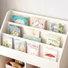A white, multi-tiered bookshelf filled with children's books. Podgląd zdjęcia produktu