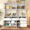 A white kitchen buffet cabinet filled with various food items, kitchenware, and decorative elements, displayed in a well-lit room. Produktbild-Vorschau