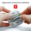 Hands inserting batteries into a device. Voir les images du produit