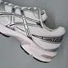 A close-up side view of a white and silver Asics running shoe. Produktbild-Vorschau