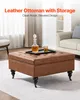A brown leather ottoman with storage is placed in a living room setting. Anteprima dell’immagine prodotto
