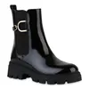 A black patent leather boot with a gold buckle detail and a thick lug sole, shown against a white background. Produktbild-Vorschau