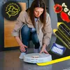 A woman is kneeling down and interacting with a white robot vacuum cleaner on a tiled floor. Various cleaning accessories are displayed in the upper right corner of the image, and a circular graphic with puzzle pieces is in the upper left corner. Voir les images du produit