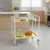 A white rolling serving cart with two yellow patterned shelves is placed in a kitchen setting. Anteprima dell’immagine prodotto