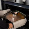 A person is taking a pot out of an oven. Náhled obrázku produktu