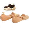 A product shot of wooden shoe trees, with a pair of brown leather shoes and a shoe tree inserted into one shoe shown in the upper left corner. Náhľad obrázku produktu