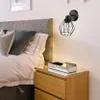 A bedroom scene with a bed, nightstand, and a wall lamp. Produktbild-Vorschau