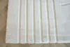 A close-up view of a white rug with a ribbed texture, lying on a wooden floor. Produktbild-Vorschau