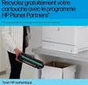 A person is holding a toner cartridge next to a printer and a recycling bin. Produktbild-Vorschau