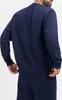 A man wearing a navy blue Nike pullover and matching sweatpants. Produktbild-Vorschau