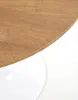 A close-up view of a round wooden table with a white base. Produktbild-Vorschau