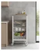 A kitchen cart with three baskets and a drawer, filled with produce and kitchen items, is shown in a modern kitchen setting. Anteprima dell’immagine prodotto