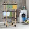 A multi-tiered clothes drying rack with clothes hanging on it, placed next to a washing machine in a laundry room. Voir les images du produit