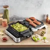 A kitchen counter scene featuring a Tefal OptiGrill with grilled salmon and zucchini. Produktbild-Vorschau