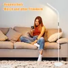 A woman is sitting on a couch and using her phone, with a floor lamp behind her. Náhľad obrázku produktu