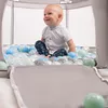A baby sitting in a ball pit. Voir les images du produit