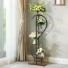 A multi-tiered plant stand with flowers is placed next to a window with curtains. Anteprima dell’immagine prodotto