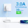 A white USB-A charger adapter plugged into a white wall socket, with a white charging cable connected to a blue smartphone. Text overlays indicate charging speed and battery percentage. Produktbild-Vorschau
