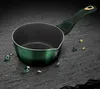A green saucepan with a dark handle sits on a dark, textured surface, surrounded by scattered green gemstones and gold nuggets. Anteprima dell’immagine prodotto