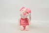 A pink plush toy piglet is sitting on a white background. Voir les images du produit