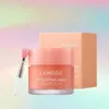 A LANEIGE Lip Sleeping Mask in Grapefruit flavor, with its applicator, and its packaging, set against a colorful, gradient background. Produktbild-Vorschau