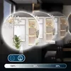 A circular mirror with a glowing edge, reflecting a room with shelves and a chandelier. The image is presented in a collage-like format with multiple overlapping circles showing slight variations of the reflection. Below the circles are icons and a gradien Voir les images du produit