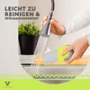 A person is rinsing a kitchen utensil under a faucet, with a plant in the background. Produktbild-Vorschau
