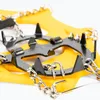 A close-up view of yellow crampons with metal spikes and chains. Produktbild-Vorschau