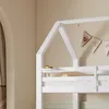 A close-up view of a white bunk bed frame with a small yellow toy car on the top railing and a decorative banner hanging above. Produktbild-Vorschau
