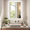 A modern bathroom vanity with a rectangular sink, black faucets, and a large illuminated mirror reflecting a window with trees outside. Podgląd zdjęcia produktu