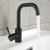 A black faucet with water running into a white sink, with a tiled wall in the background. Podgląd zdjęcia produktu