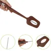 A hand holds a brown digital thermometer spatula. Podgląd zdjęcia produktu