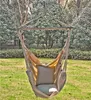 A hanging chair with cushions is set up outdoors in a garden with trees and grass. Produktbild-Vorschau