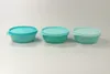 Three Tupperware containers of varying shades of turquoise and green are lined up on a white surface. Anteprima dell’immagine prodotto