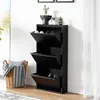 A black shoe cabinet with three flip-down drawers is shown against a white wall and next to a wicker basket with blankets. Náhľad obrázku produktu